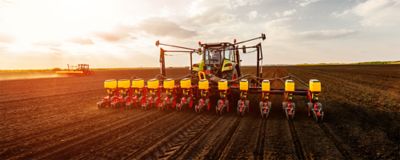 seed planter tractor in field at sunrise