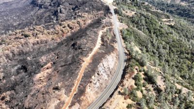 Devastation from the Park Fire is seen on the left. The shaded fuel break (right) protected the homes beyond.