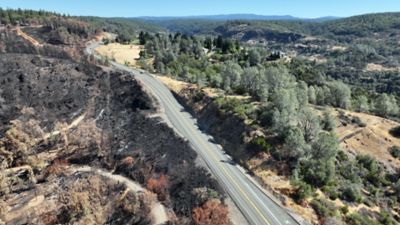View of expansive damage from the Park Fire (left) and the undamaged landscape beyond the shaded fuel break (right).