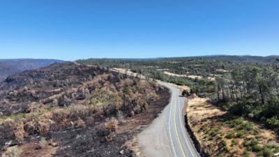 Wide view of Highway 32 showing fire damage on left, and area protected by shaded fuel break on right.
