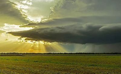 stormy clouds accumulating over farmland