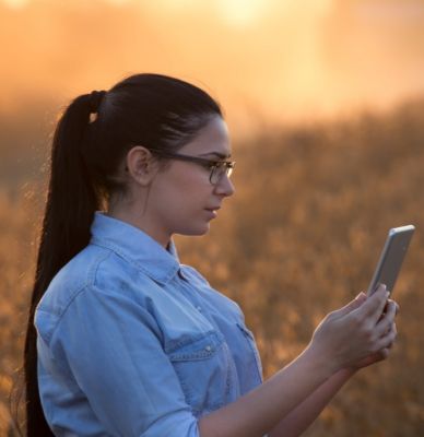 woman in field with iPhone