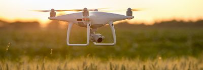 Drown flying over field at sunrise