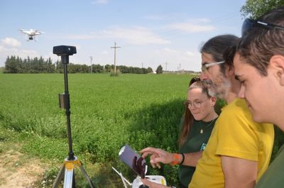 El profesor Jorge Andrés y dos alumnos, vigilando el vuelo de un dron en el campo. 