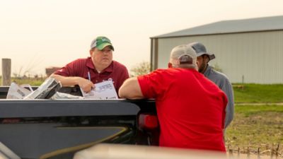 Three men standing at a truck tailgate