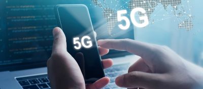 imagem de um homem segurando um celular com um notebook ao fundo. Aparecem elementos que remetem tecnologia sob a imagens e há um texto escrito 5G