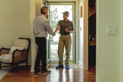 Certified Sentricon Specialist greets male homeowner in front entry