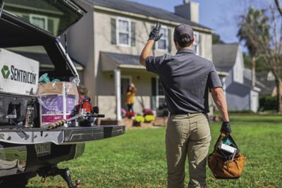 Sentricon certified specialists waves to homeowners from back of his truck