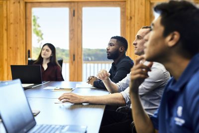 Grupo diversificado sentado ao redor de uma mesa de conferência