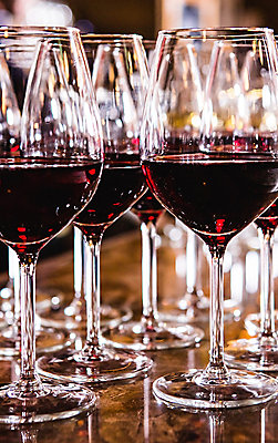 Wine glasses with red wine on bar with blurred background