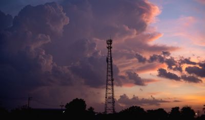 communications tower against sunset sky