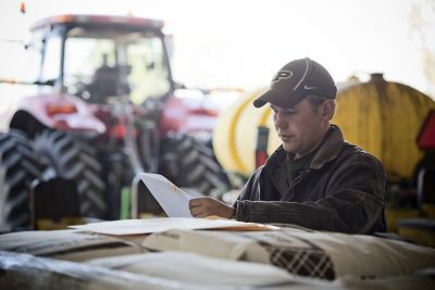 Farmer in barn reviewing invoice