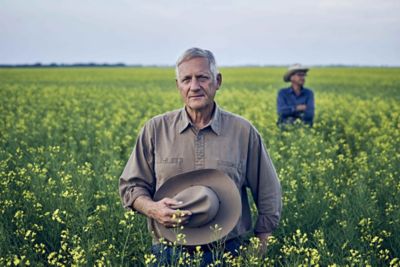 Man in field holding hat