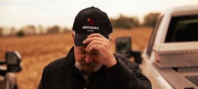 Man in field adjusting his Brevant seeds hat