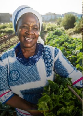 Smiling female farmer holding crops