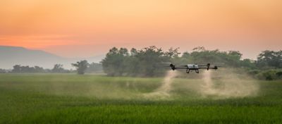 spray drone flying over pasture