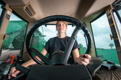 Woman farmer driving a tractor - interior view