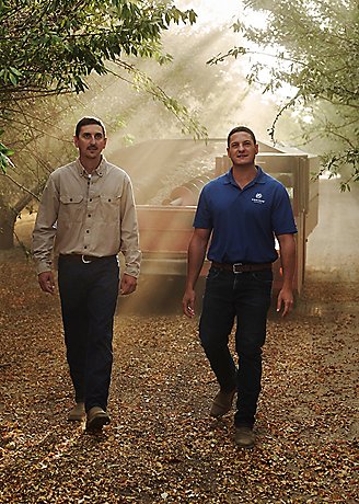 two men walking in woodsy area