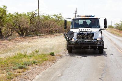 White truck spraying along roadside in TX