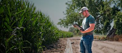 Sustainability in agriculture young male farmer using tablet inspects corn crop