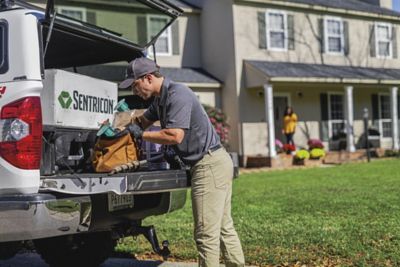Certified Sentricon Specialist loading bag on back of truck