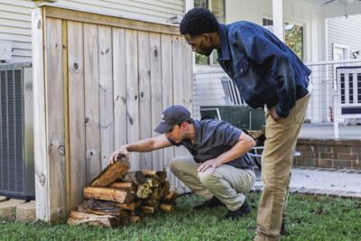 Certified Sentricon Specialist shows homeowner termite activity located in a wood pile