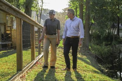 Certified Sentricon Specialist speaks with malle homeowner while walking along fence line.