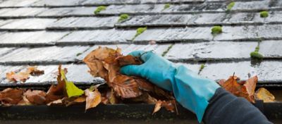 Homeowner clearing their gutters