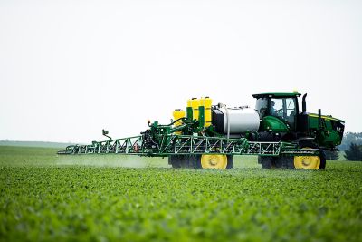 Green sprayer in young soybean field