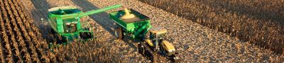 Harvesting operation - green combine and tractor