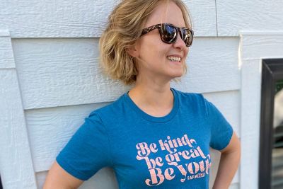 Dr. Magan Lewis standing by a wall wearing sunglasses