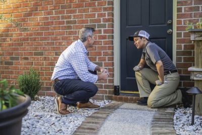 A man kneels next to a Certified Sentricon Specialist and installed 