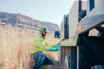 Man preparing spray equipment on truck