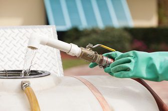pest control technician putting water into a chemical tank