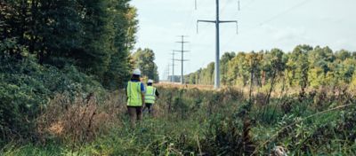 people walking along powerlines