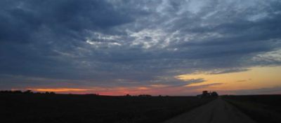 Sunset - clouds and farm machinery in background