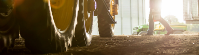 Tractor in barn; farmer with jug of herbicide