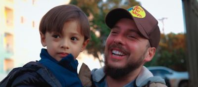 Pai sorrindo com filho no colo