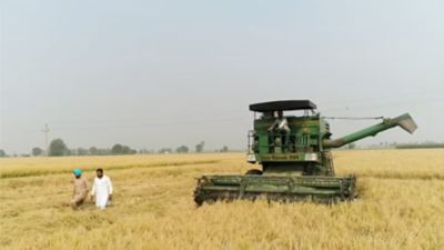 two men walking in field with farm equipment
