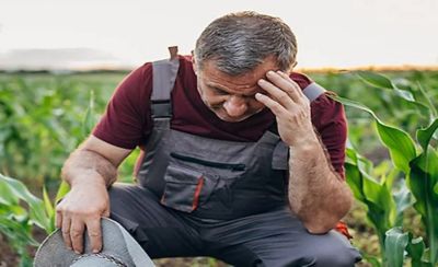 man kneeling in field