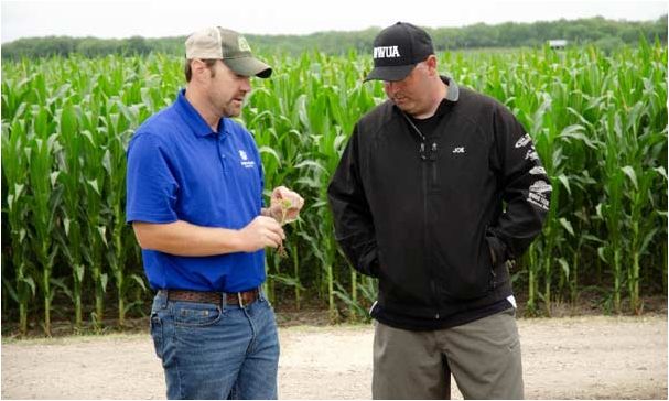 Pioneer Territory Manager Ryan Harms sharing crop management information with a S.A.V.E. participant.