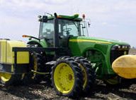 John Deere tractor equipped with tanks for liquid starter application at planting.
