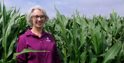 Photo of Corteva senior research scientist Ana Locatelli standing in a corn field. Photo taken at Corteva's research center in Passo Fundo, Brazil.