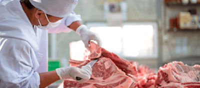 Açougueiro cortando uma peça de carne bovina