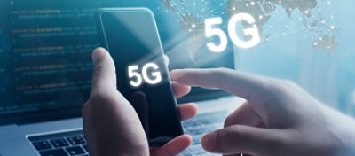 imagem de um homem segurando um celular com um notebook ao fundo. Aparecem elementos que remetem tecnologia sob a imagens e há um texto escrito 5G
