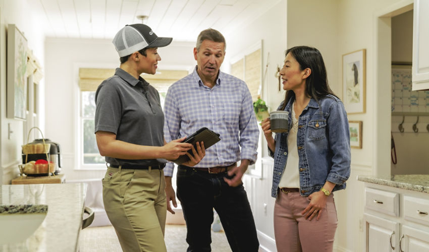 Certified Sentricon Specialist speaks to a male and female homeowner
