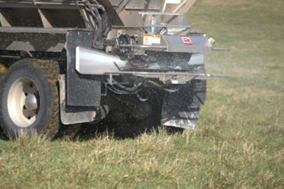 Fans spreading fertilizer in pasture