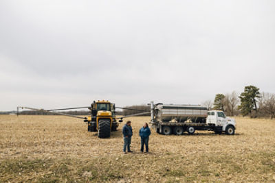 Farmers in harvested field, nitrogen stabilizer applications