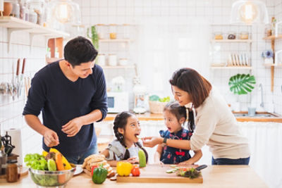 Family standing at a table with a lot of colorful vegetables