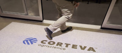 Man walking in office door with Corteva logo on carpet